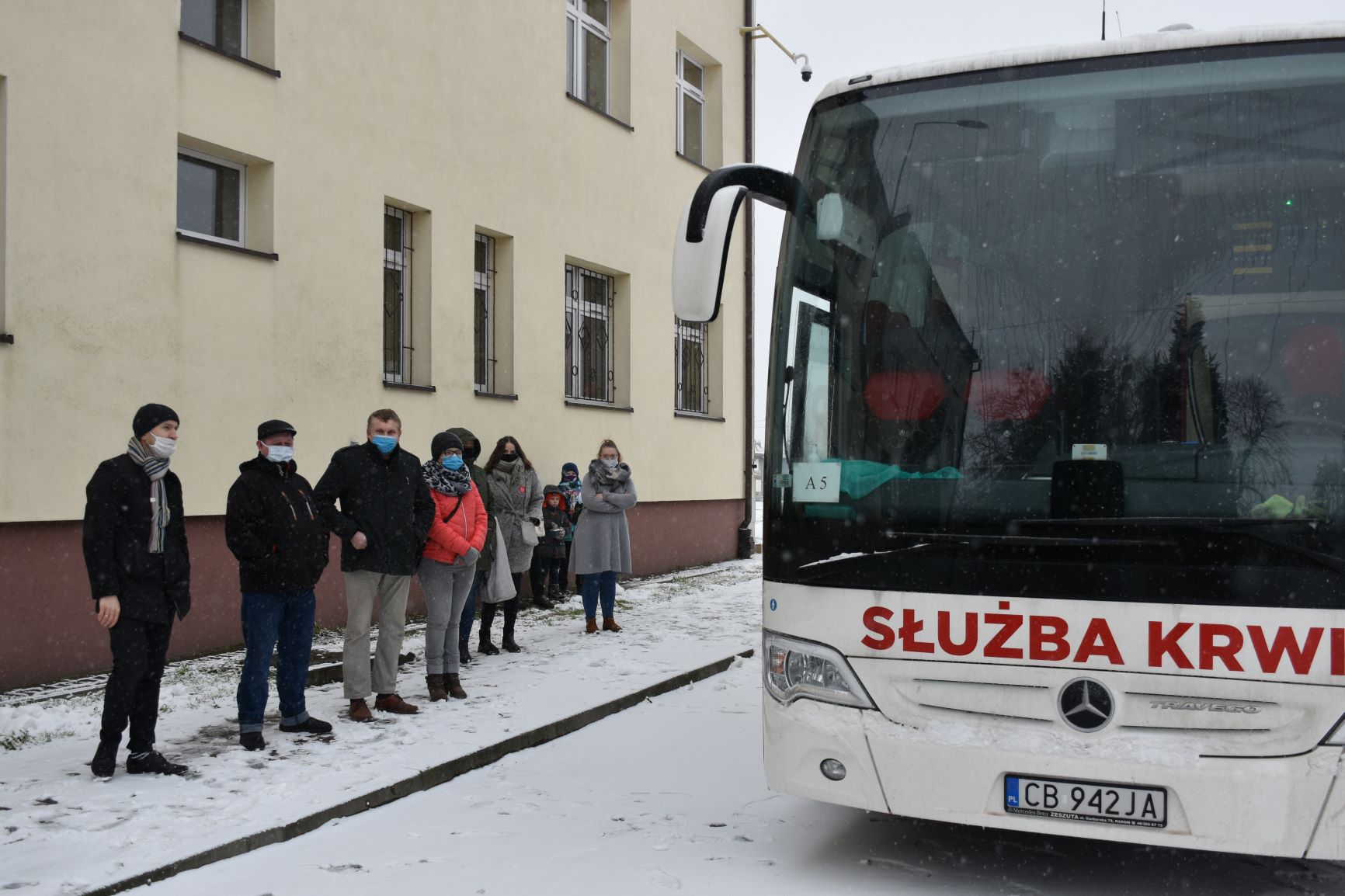 Ochotnicy stoją w kolejce przed krwiobusem